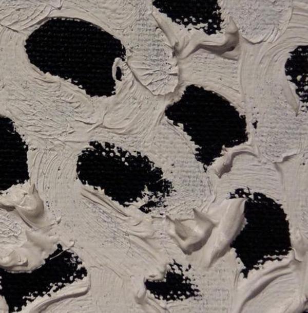 A detail of the Kusama painting. The white paint looks like a series of mountains, there are about 4 or 5 black dots clearly visible